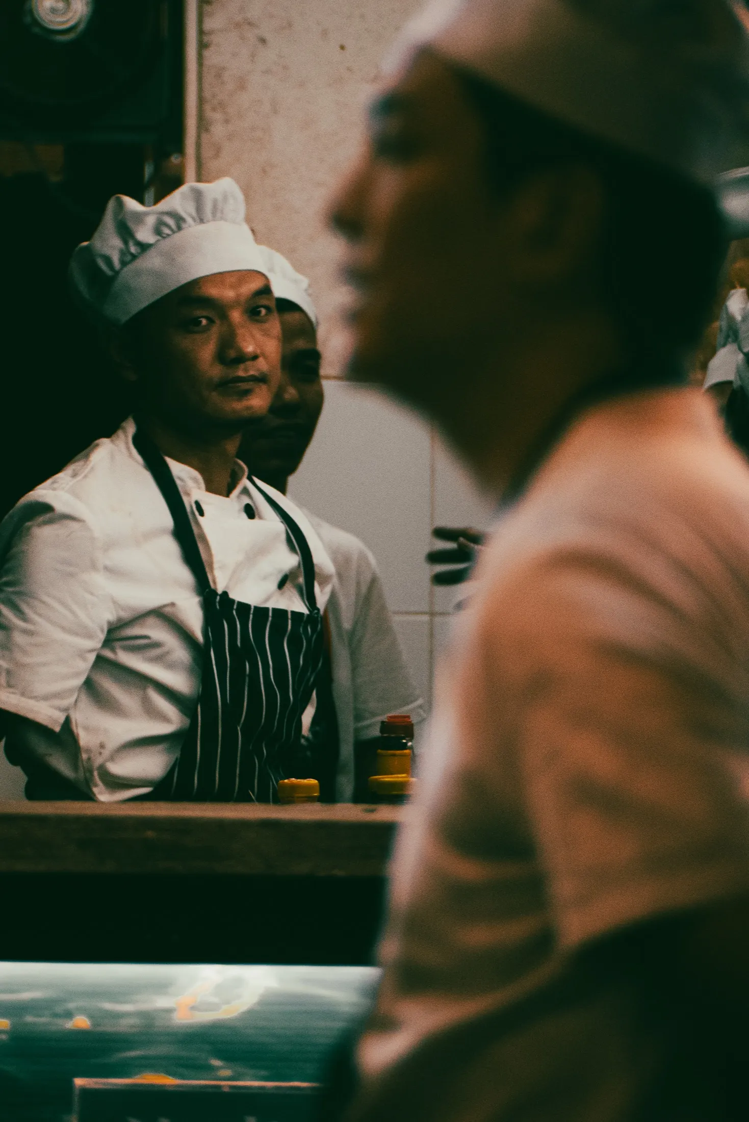 A worker looks across a counter during a conversation