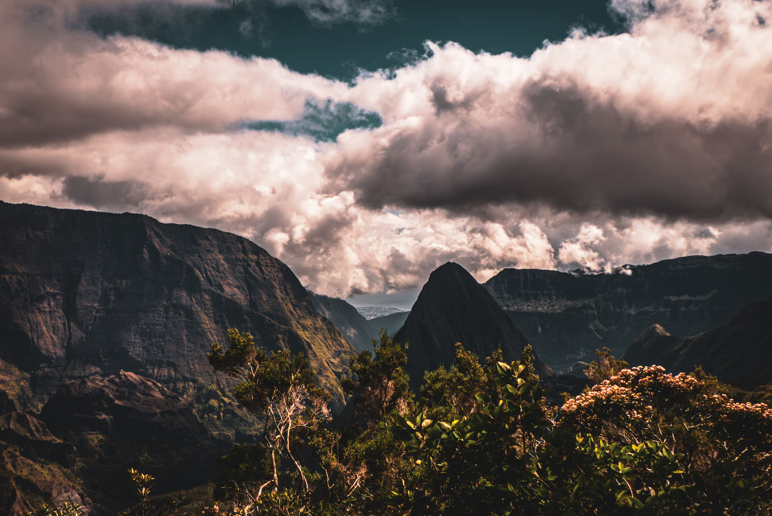 Cloud gathers over the ridges and rock spires of an eroded volcanic cirque.